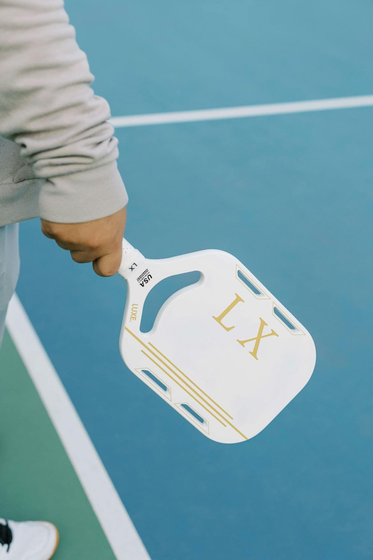 New player holding pickleball paddle on court